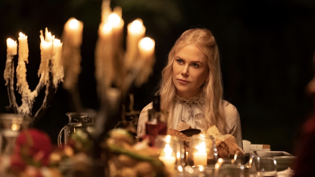 Masha (Nicoe Kidman) sitting at a set dinner table in Nine Perfect Strangers.