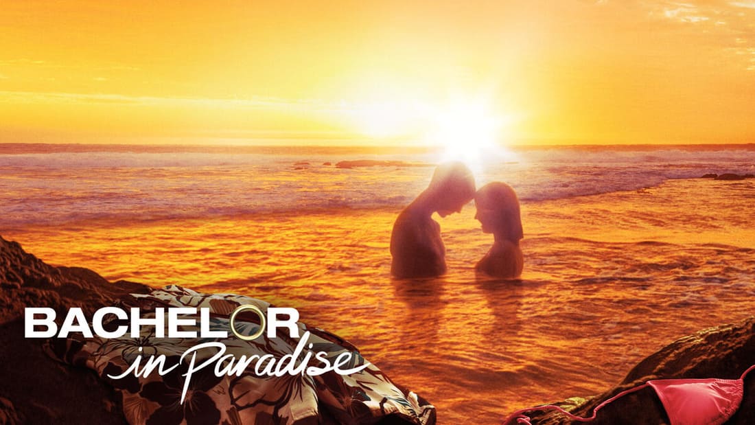 Couple embracing one another in the water at sunset.